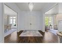 Grand foyer with hardwood floors, chandelier, and double doors at 2710 Cambridge Rd, Raleigh, NC 27608