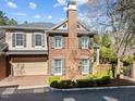 Attractive two-story brick home featuring a chimney, manicured bushes, and an iron gate to backyard at 2820 Glenwood Gardens Ln # 101, Raleigh, NC 27608