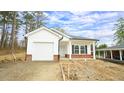 Charming single-story home with white siding, a garage, and a partially landscaped yard at 303 E C St, Butner, NC 27509