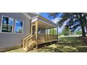 A cozy covered porch with wooden steps and railings, perfect for enjoying the outdoors at 33 White Azalea Way, Homesite 80, Benson, NC 27504
