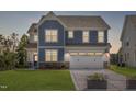 Charming two-story home with blue siding and a well-manicured lawn at 33 White Azalea Way, Homesite 80, Benson, NC 27504
