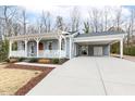 Charming light blue home featuring a covered porch and convenient side carport at 3650 Durwood Ln, Raleigh, NC 27604