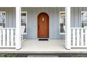 Inviting front porch with rocking chairs and a beautiful wood door at 3650 Durwood Ln, Raleigh, NC 27604