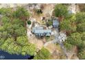 An aerial view of a brick home with a circular driveway and lush surrounding greenery and lake at 3715 Rawls Church Rd, Fuquay Varina, NC 27526