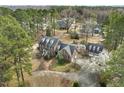 Aerial view of brick home with detached garage, playset, circular driveway and mature trees at 3715 Rawls Church Rd, Fuquay Varina, NC 27526