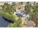Aerial view of a brick home with detached garage, lake and lush surrounding greenery at 3715 Rawls Church Rd, Fuquay Varina, NC 27526