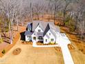 Aerial view of a modern farmhouse with a sprawling lawn, long driveway, and wooded surroundings at 3901 Laurel Creek Ln, Wake Forest, NC 27587