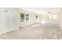 Bright living room featuring neutral carpet, white walls, and natural light from multiple windows at 4508 Regis Ave, Durham, NC 27705