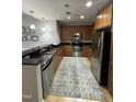 Efficient kitchen features stainless appliances, wood cabinets and long granite countertop at 618 N Boylan Avenue # 300, Raleigh, NC 27603