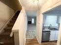 Foyer view features stairs and entry into kitchen and living room with fireplace at 6221 Tributary Dr, Raleigh, NC 27609
