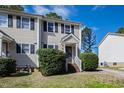 A well maintained multi-Gathering unit with neutral siding, black shutters, and green bushes at 6225 Tributary Dr, Raleigh, NC 27609