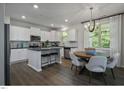 Modern kitchen with white cabinets, stainless steel appliances, and adjacent dining area at 69 White Azalea Way, Homesite 81, Benson, NC 27504