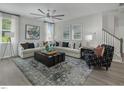 Bright living room featuring a decorative rug, stylish seating, and a large window at 69 White Azalea Way, Homesite 81, Benson, NC 27504