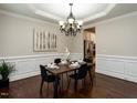 Elegant dining room featuring wainscoting, tray ceiling, chandelier, and hardwood floors at 730 Toms Creek Rd, Cary, NC 27519