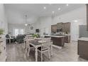 Open concept kitchen, dining, and living room with vaulted ceilings and hardwood floors at 74 Powderhorn Pt, Garner, NC 27529