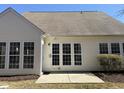 Back exterior featuring light siding, a series of windows, and a small concrete pad at 812 Gillinder Pl, Cary, NC 27519