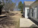 A house back entrance with light siding, a small concrete pad, and a view of the backyard at 812 Gillinder Pl, Cary, NC 27519
