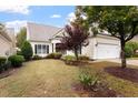 Inviting home exterior with lush lawn, complemented by mature trees, shrubbery and light siding at 812 Gillinder Pl, Cary, NC 27519