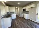 Modern kitchen with white cabinets, granite countertops, stainless steel appliances, and wood-look flooring at 91 Lotus Ave, Smithfield, NC 27577
