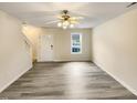 An empty, freshly painted living room with hardwood floors, a ceiling fan, and a window at 910 Savin Lndg, Knightdale, NC 27545
