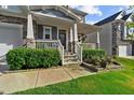 Charming front porch with stone accents, white railings, and well-manicured landscaping at 1025 Bender Ridge Dr, Morrisville, NC 27560