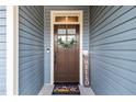 Close-up of the beautiful wood front door with decorative wreath and sidelight at 105 Anderson Park Dr, Youngsville, NC 27596