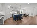 Open-concept kitchen and dining area with a center island and modern lighting fixture at 112 Pointe Park Cir, Holly Springs, NC 27540