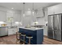Bright kitchen boasts a center island with seating, stainless appliances and pendant lights at 112 Pointe Park Cir, Holly Springs, NC 27540