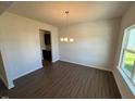 Dining room featuring wood floors, natural light from a large window, and stylish chandelier at 120 W Victory View Ter # 51, Smithfield, NC 27577