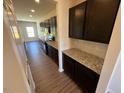 Modern kitchen featuring dark cabinets, granite countertops, stainless steel appliances, and a tiled backsplash at 120 W Victory View Ter # 51, Smithfield, NC 27577