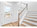 Bright entryway showcasing a staircase with wooden handrail and wood-look flooring at 1201 Canary Pepper Dr, Durham, NC 27713