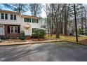 Exterior view of a two-story townhome featuring a well maintained lawn with mature trees and shrubs at 121 Westview Dr # 106, Carrboro, NC 27510