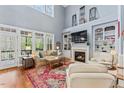 Bright living room featuring hardwood floors, a fireplace, and large windows overlooking the greenery at 1425 Princess Anne Rd, Cary, NC 27607