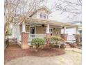 Charming exterior showcasing a covered porch with brick pillars and a well-maintained landscaped yard at 1426 N Roxboro St, Durham, NC 27701