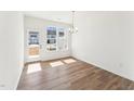 Bright dining area featuring hardwood floors, a modern chandelier, and large windows with natural light at 1430 Cooper St, Sanford, NC 27330
