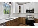 Modern kitchen with stainless steel appliances, a stylish faucet, white subway tile backsplash, and elegant two-tone cabinets at 149 Amber Rd, Timberlake, NC 27583