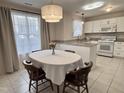 Cozy dining area with a round table, chandelier lighting and a view of the updated kitchen at 1613 Bulon Dr, Cary, NC 27518