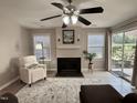 Cozy living room with fireplace, ceiling fan, and sliding glass doors to the outside at 1613 Bulon Dr, Cary, NC 27518