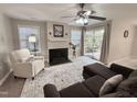 Comfortable living room with a fireplace, ceiling fan, and sliding glass doors to the outside area at 1613 Bulon Dr, Cary, NC 27518