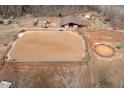 Aerial view of horse property with riding ring, stable, and outbuildings at 195 Falcon Ln, Rougemont, NC 27572