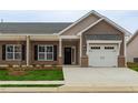 Inviting home exterior with brick and siding, attached garage, and a neatly manicured front lawn at 210 Cason Dr, Gibsonville, NC 27249