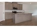 Modern kitchen with a large island, granite countertops, stainless steel appliances and wood grain floors at 210 Cason Dr, Gibsonville, NC 27249