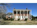 Elegant brick home boasts large white columns and shutters, enhancing its traditional charm at 2200 N Nc 49 Hwy, Burlington, NC 27217