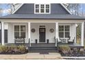 Inviting front porch features seating, dark wood flooring, and decorative accents creating a cozy outdoor space at 228 Sacred Fire Rd, Louisburg, NC 27549