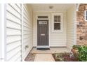 Inviting entryway featuring a neutral-toned door, stone accents, and manicured landscaping for a welcoming appeal at 2314 Wispy Green Ln, Raleigh, NC 27614