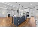 Open-concept kitchen featuring a large island with marble countertop and stainless steel appliances at 2912 Oakley Woods Ln, Apex, NC 27539