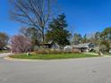 Charming blue two-story home nestled in a serene setting with a gazebo and a beautiful flowering tree at 310 Electra Dr, Cary, NC 27513