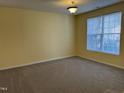 Bright bedroom with soft carpet, a large window, and neutral wall color, offering a cozy atmosphere at 316 Arbor Greene Dr, Garner, NC 27529