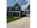 Charming two-story home with a covered front porch, well-manicured lawn, and two car garage at 321 Kavanaugh Rd, Wake Forest, NC 27587