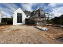 Two story home with white stucco and black trim and window frames under construction at 3405 Makers Circle, Raleigh, NC 27612
